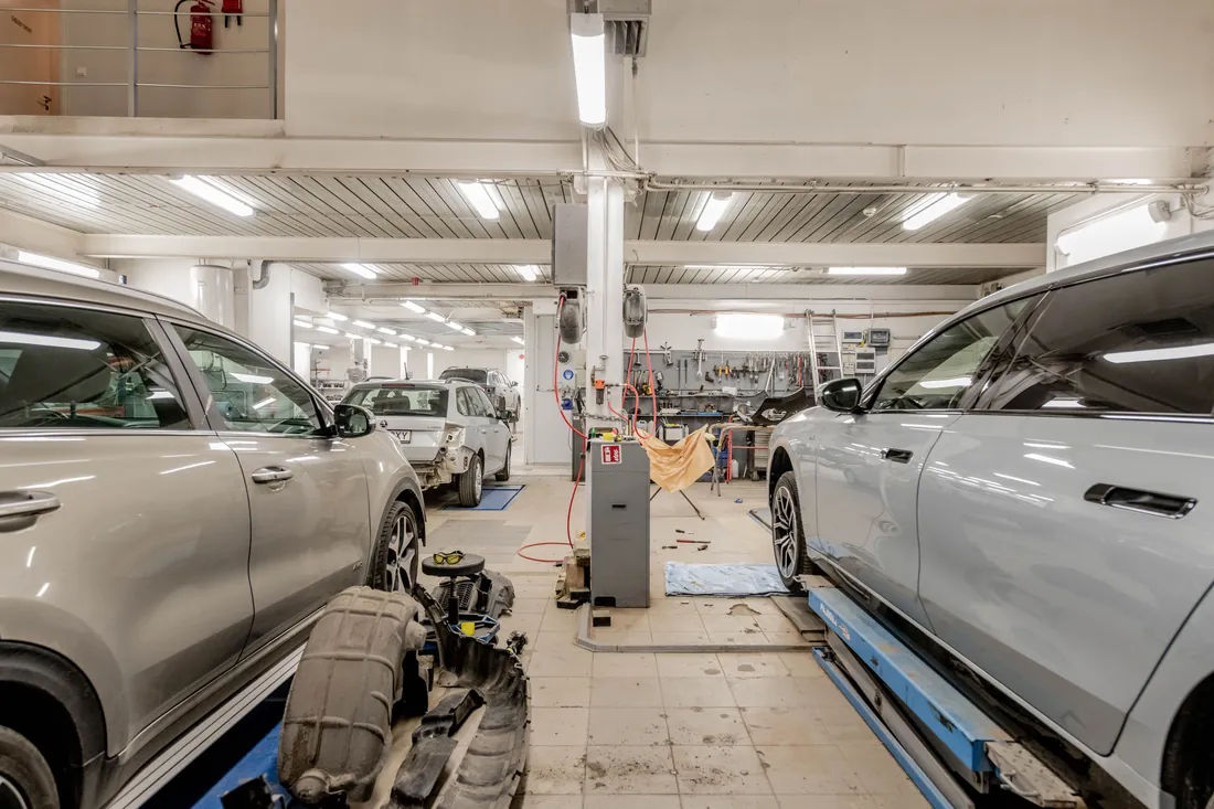 Cars on lifts inside an auto repair shop