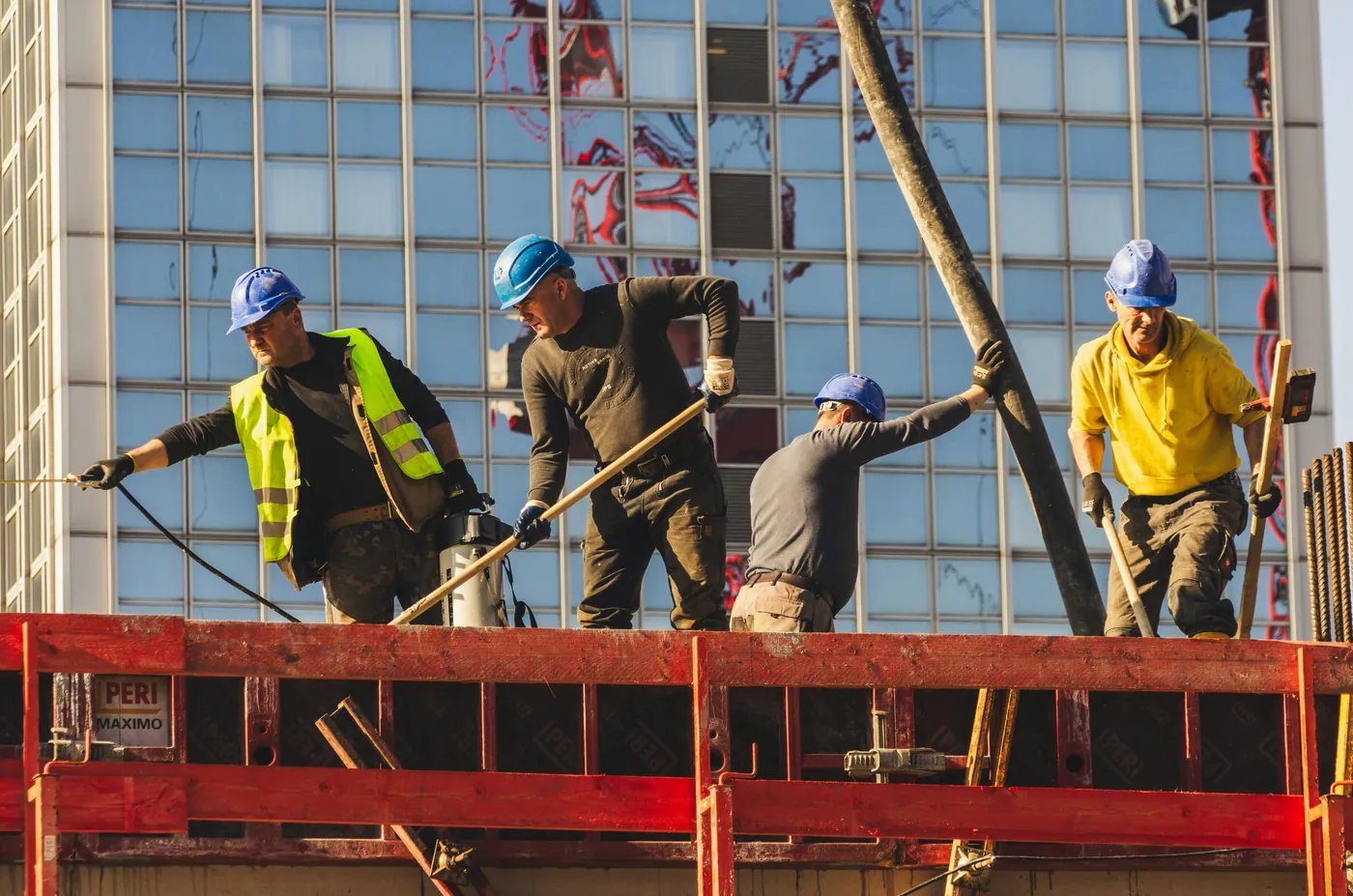 Construction crew in hard hats pouring and finishing concrete on a job site — illustrating the operating environment of a small construction or contracting business