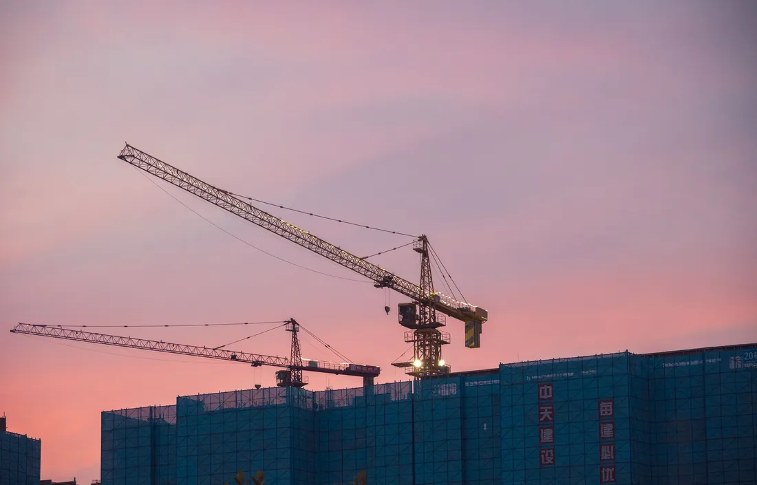 Construction site with tower cranes at dusk