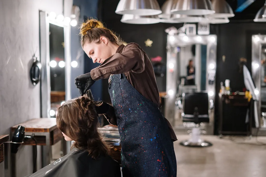 Stylist coloring a client's hair in a salon