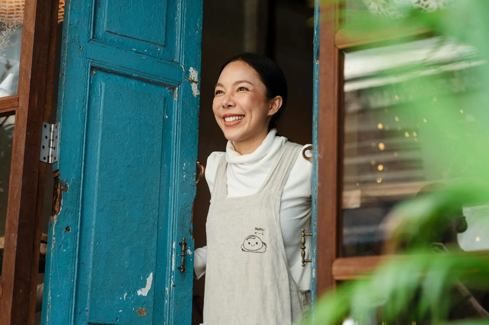 Confident small business owner standing in the doorway of their shop